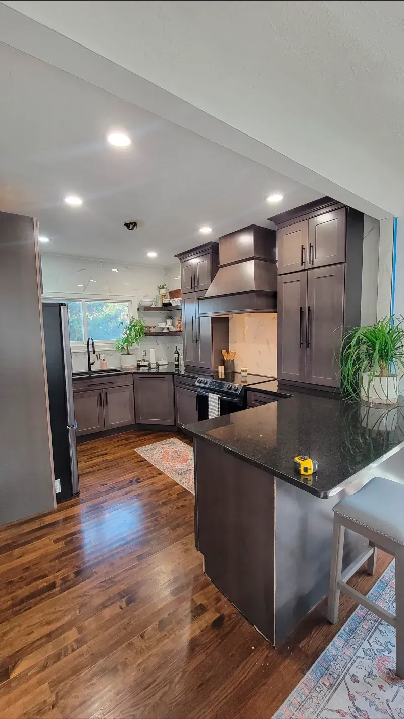 A kitchen with hardwood floors and stainless steel appliances.