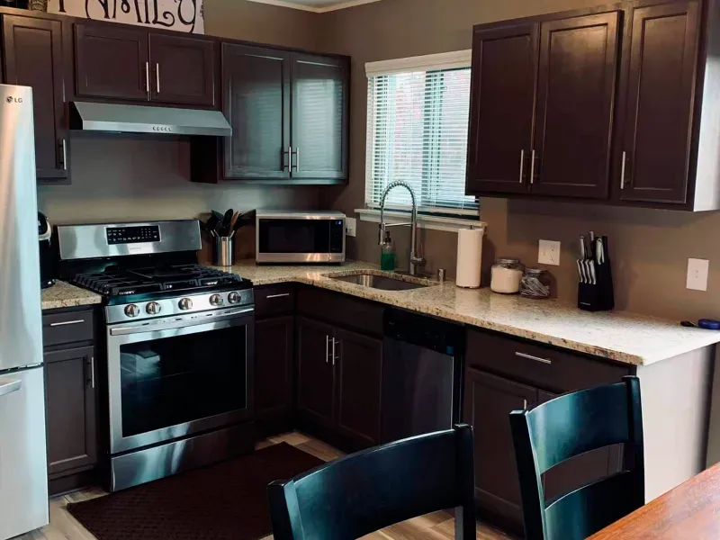 A kitchen with stainless steel appliances and brown cabinets