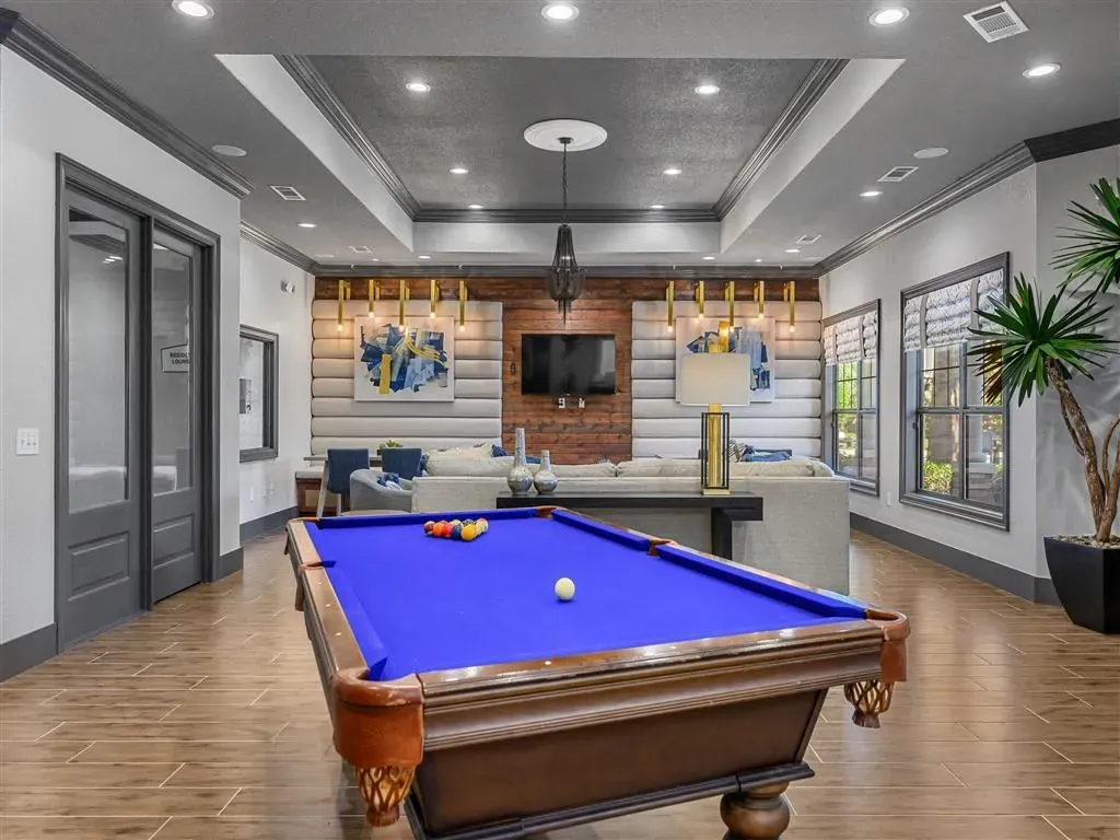 Community lounge with a pool table, seating area, and decorative elements.