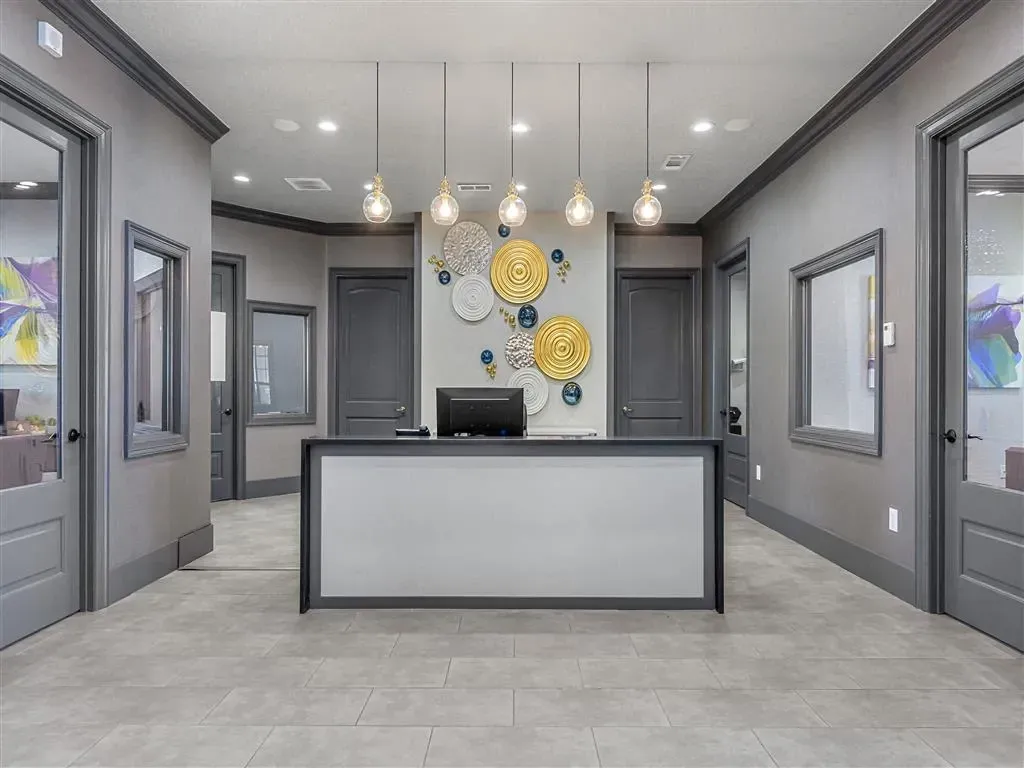 Reception desk with modern decor and artwork in apartment complex lobby.