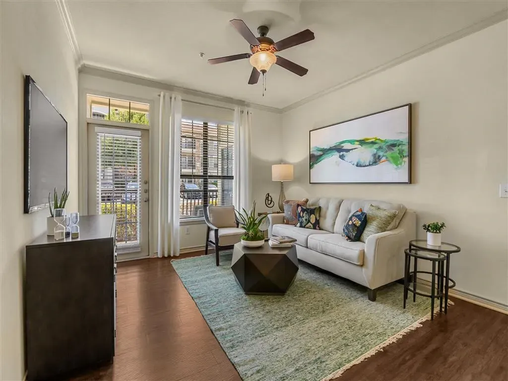 Living room with a couch, coffee table, armchair, and a TV.