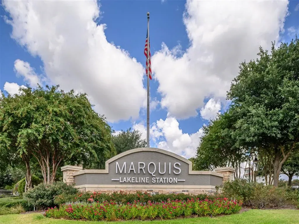Marquis Lakeline Station monument sign with American flag and landscaping.