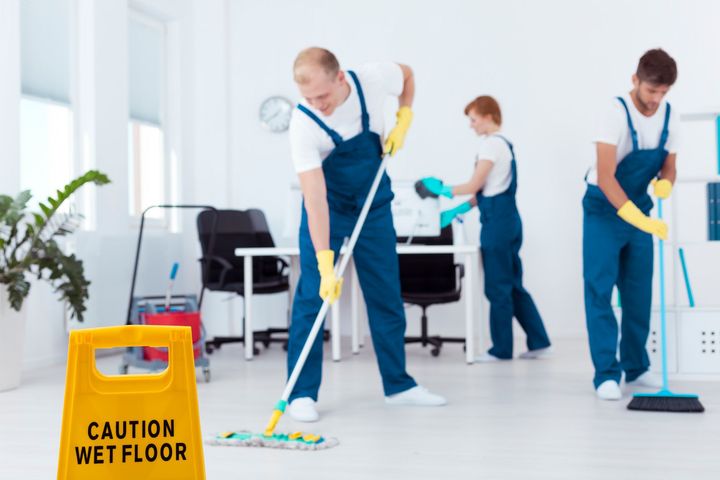 A man is using a vacuum cleaner to clean a rug in a living room.