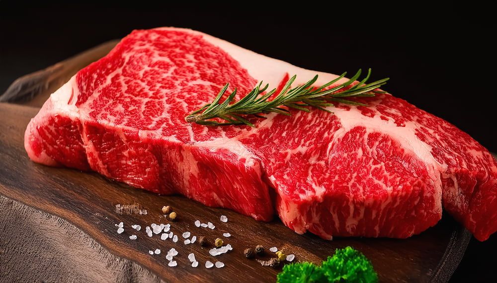 A Large Piece Of Raw Steak Is Sitting On Top Of A Cutting Board — Wattle Butchery In Cootamundra, NSW