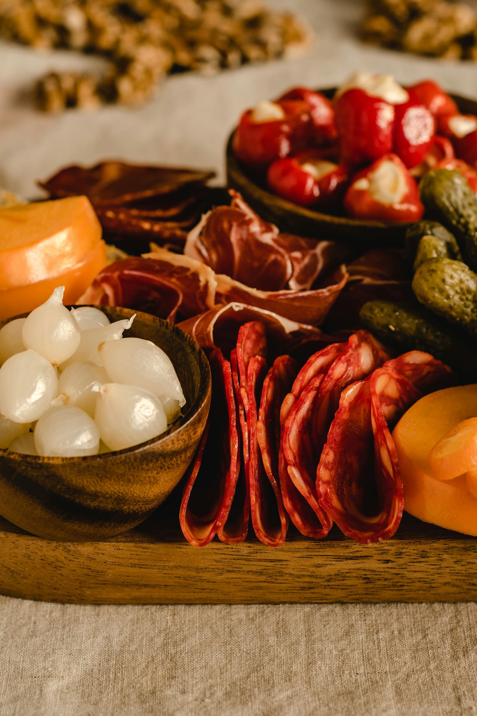 Charcuterie board with meats, cheeses, pickled onions, peppers, and pickles.