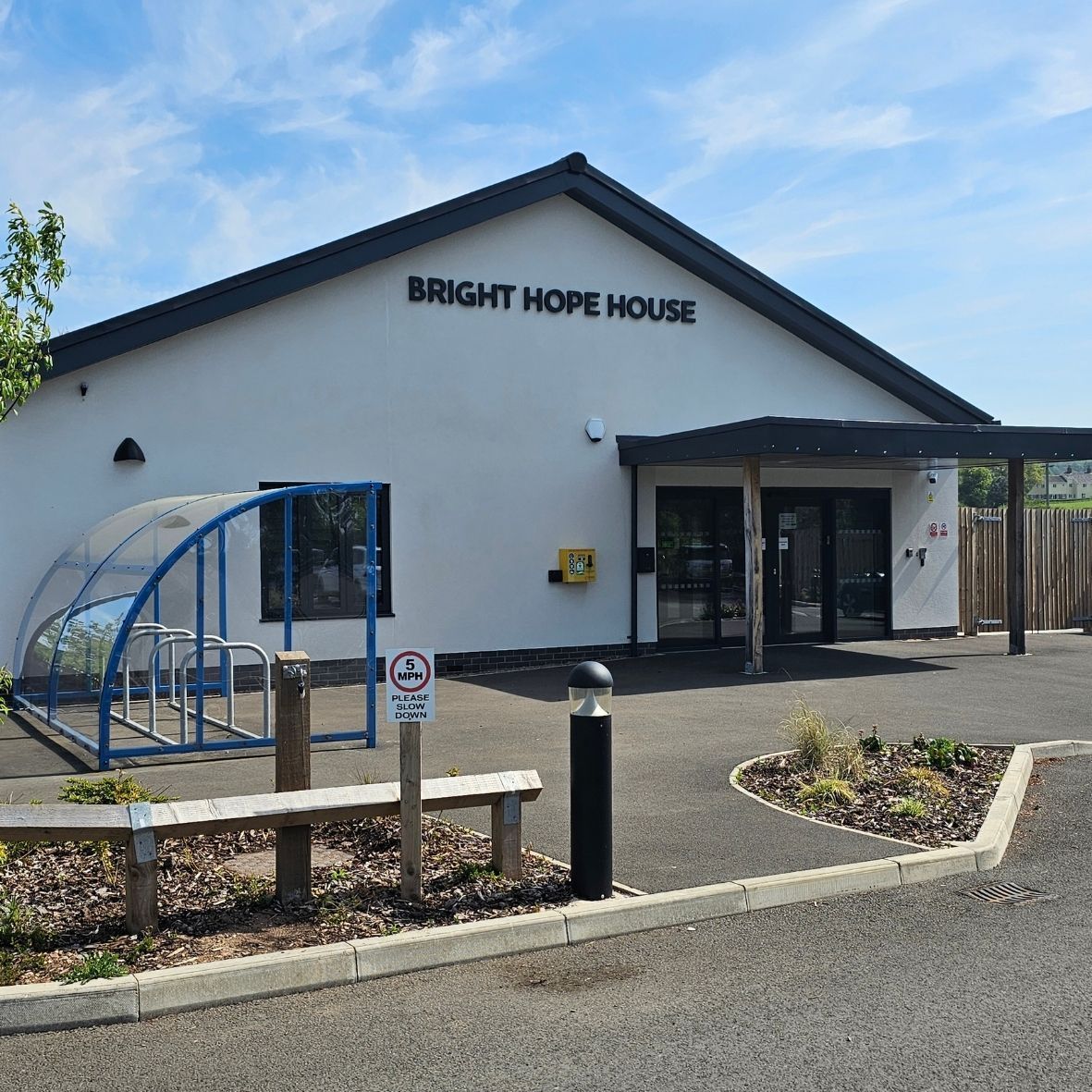 Bright Hope House building exterior with white walls, blue roof trim, and accessible ramp entrance