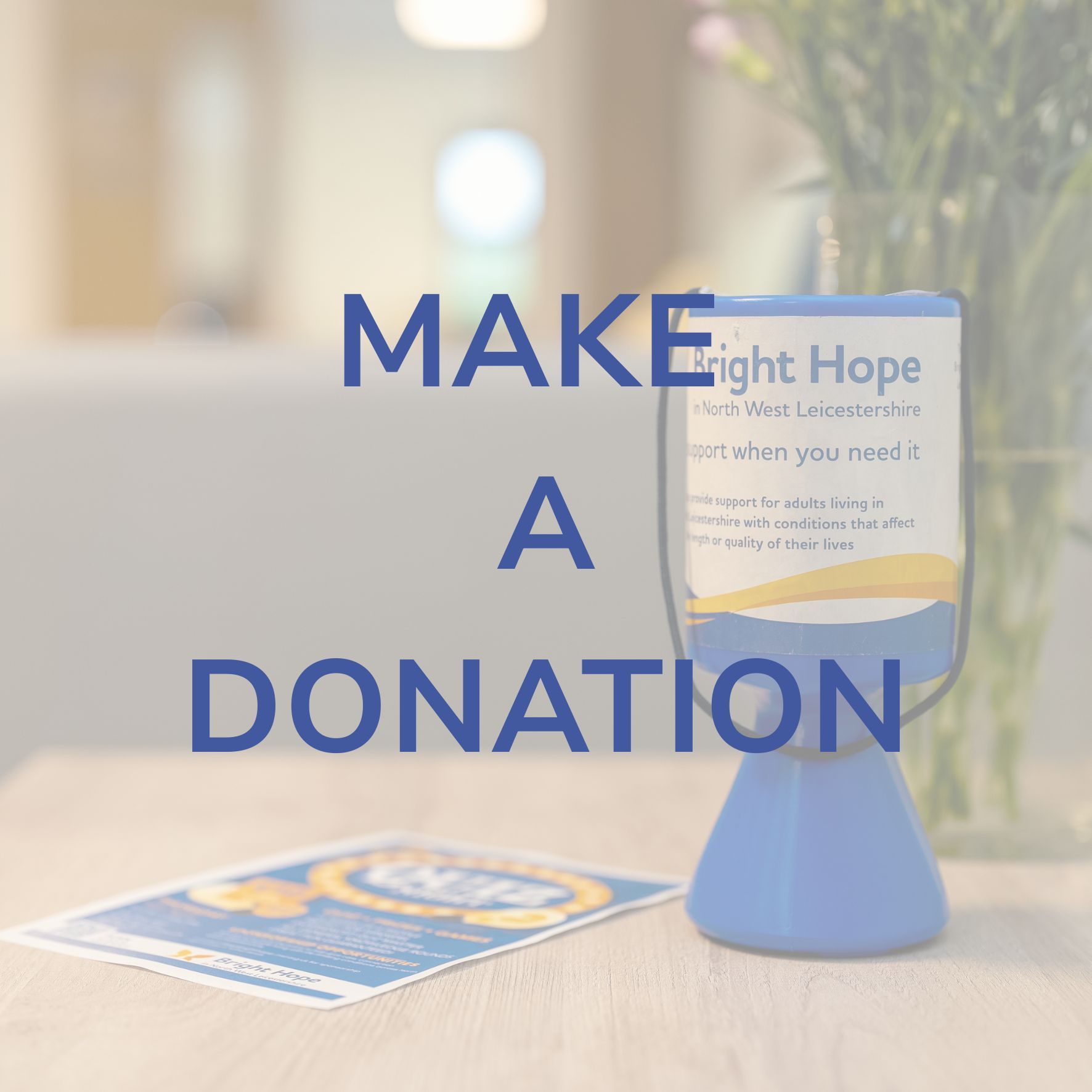 Make a donation sign beside a blue donation jar on a table