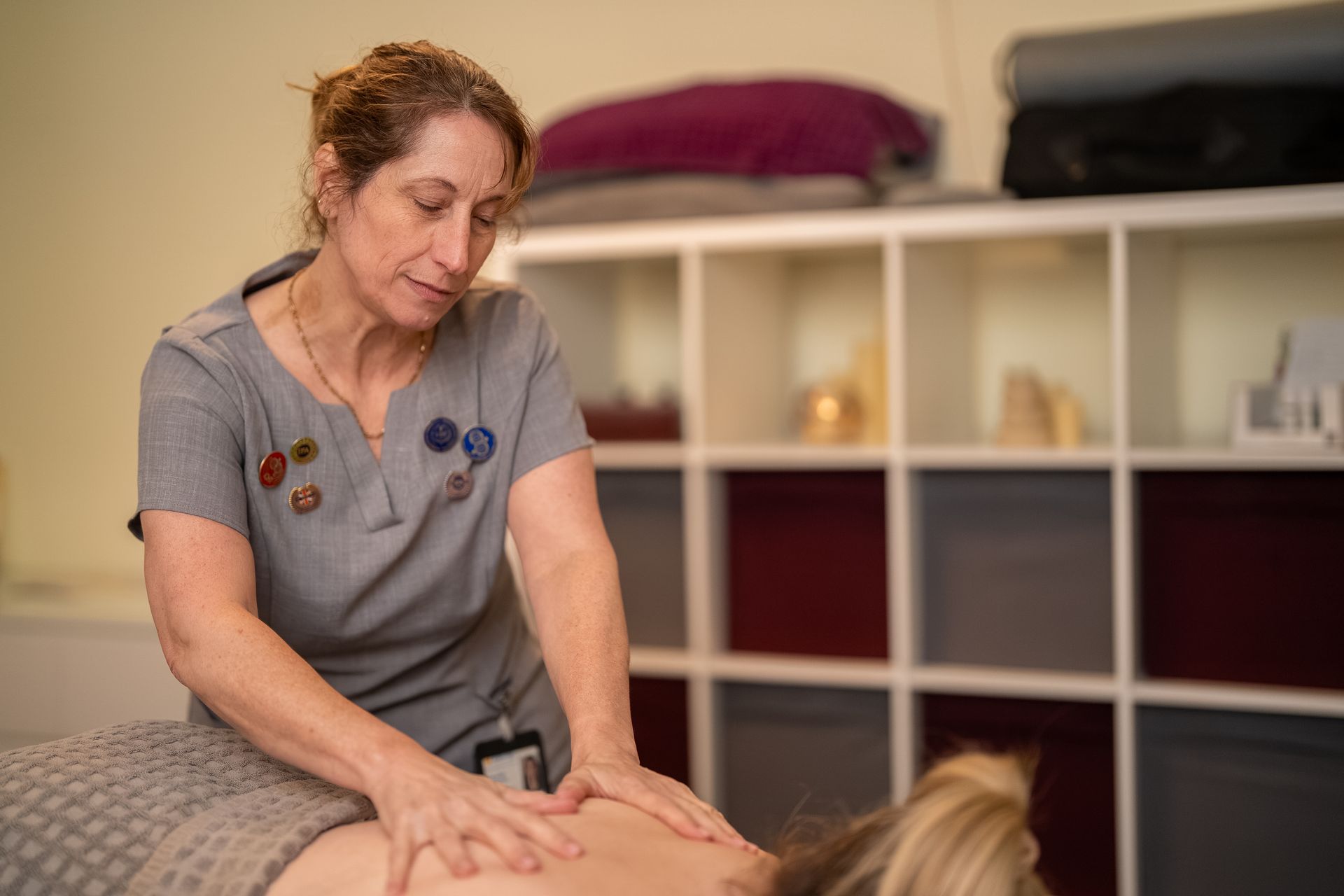 Massage therapist giving a back massage in a calm treatment room