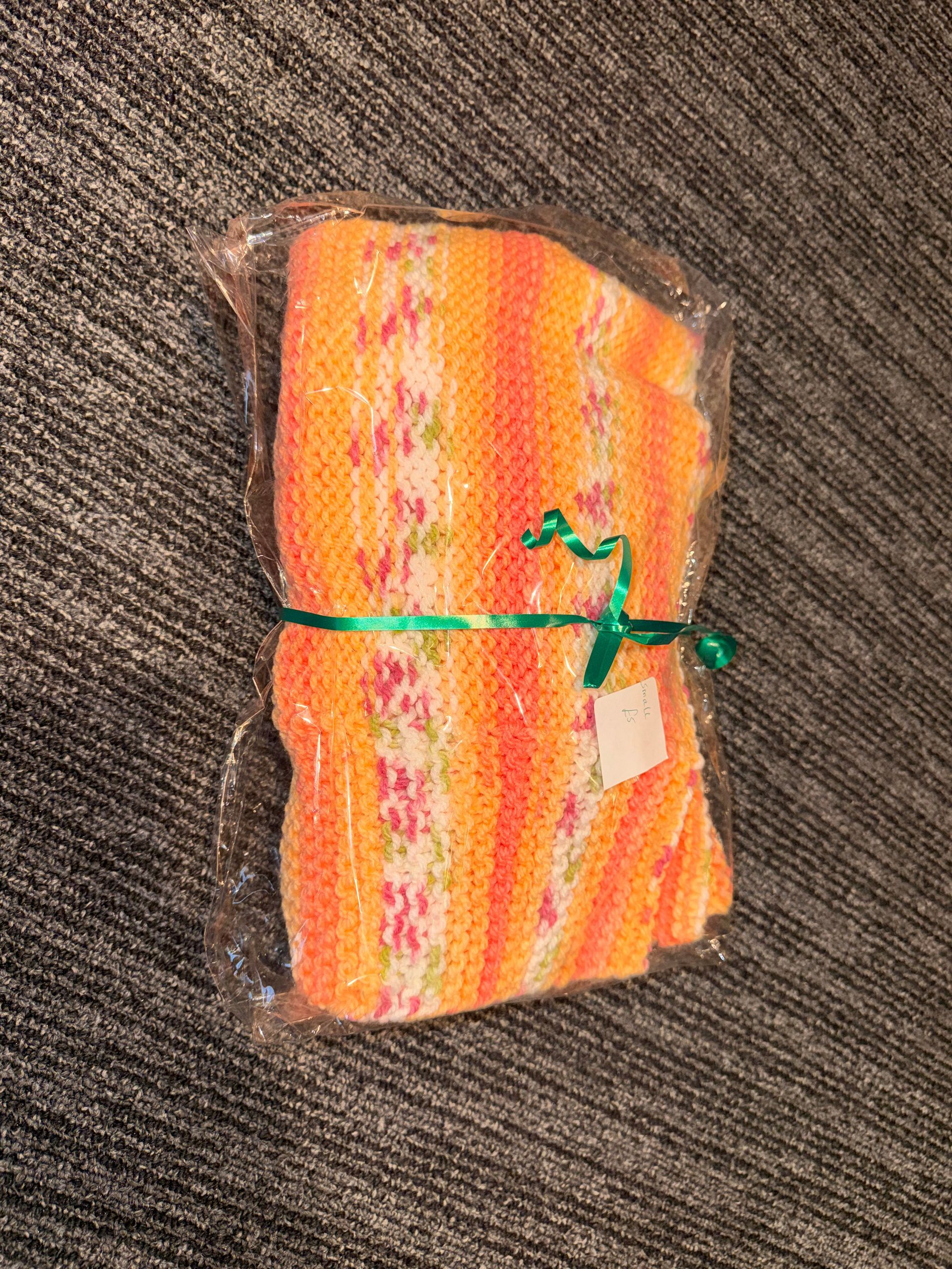 Red rolled blanket or towel tied with yellow ribbon on a brown textured surface