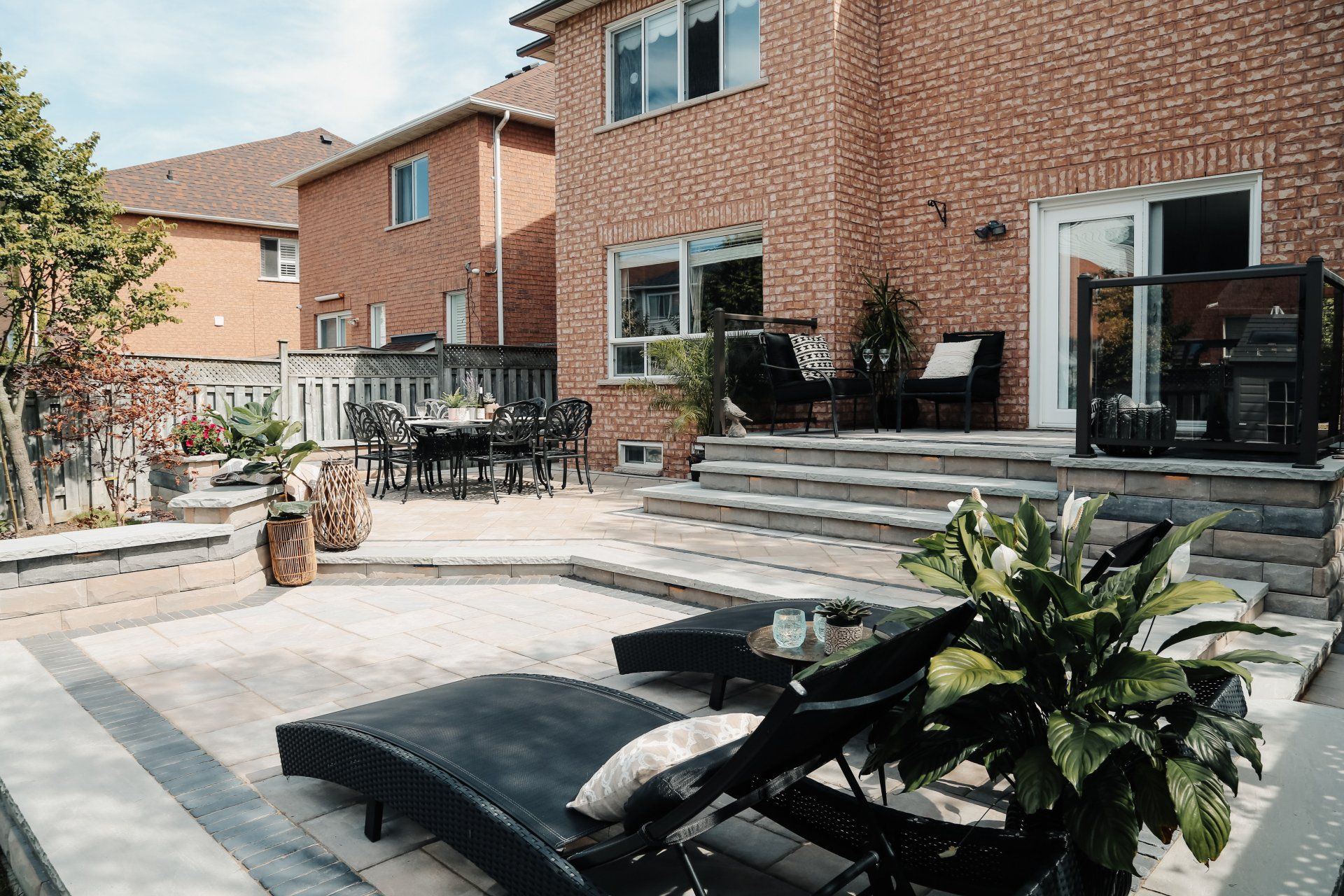 A large brick house with a patio with chairs and a table.