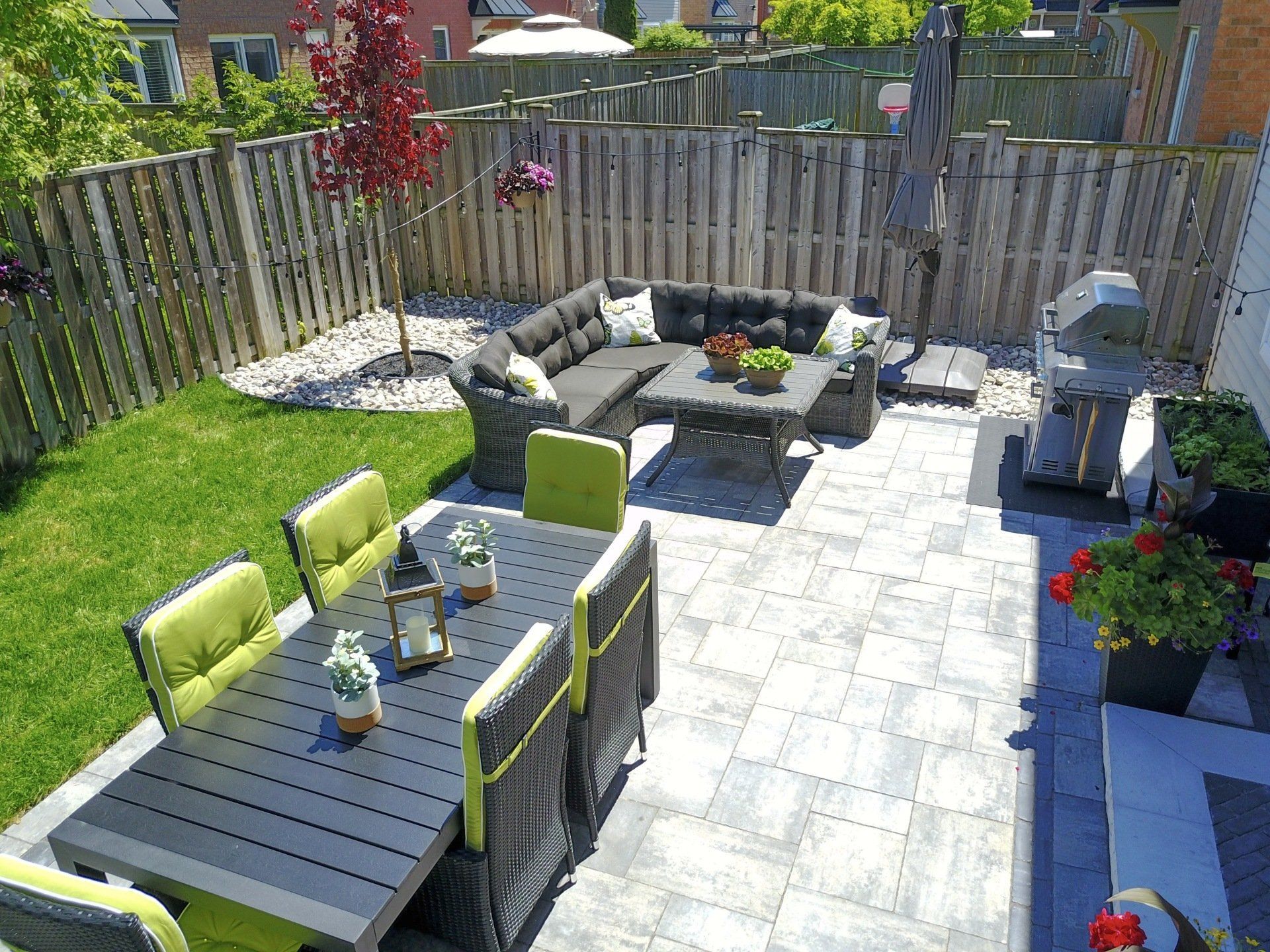 There is a patio with a table and chairs in the backyard.