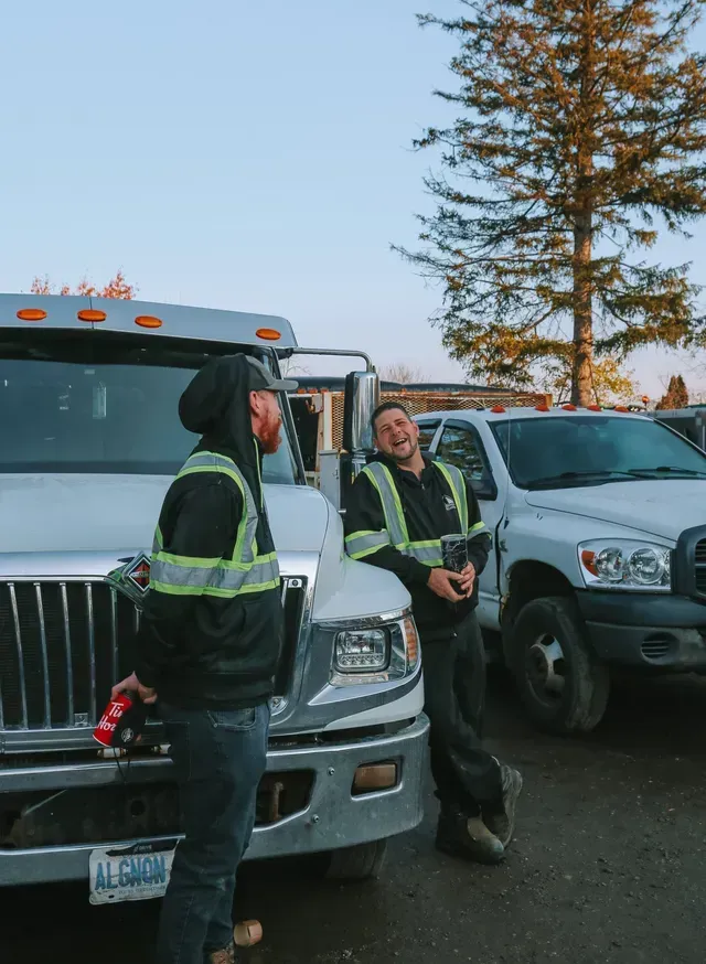 Two men are standing next to a truck in a parking lot.