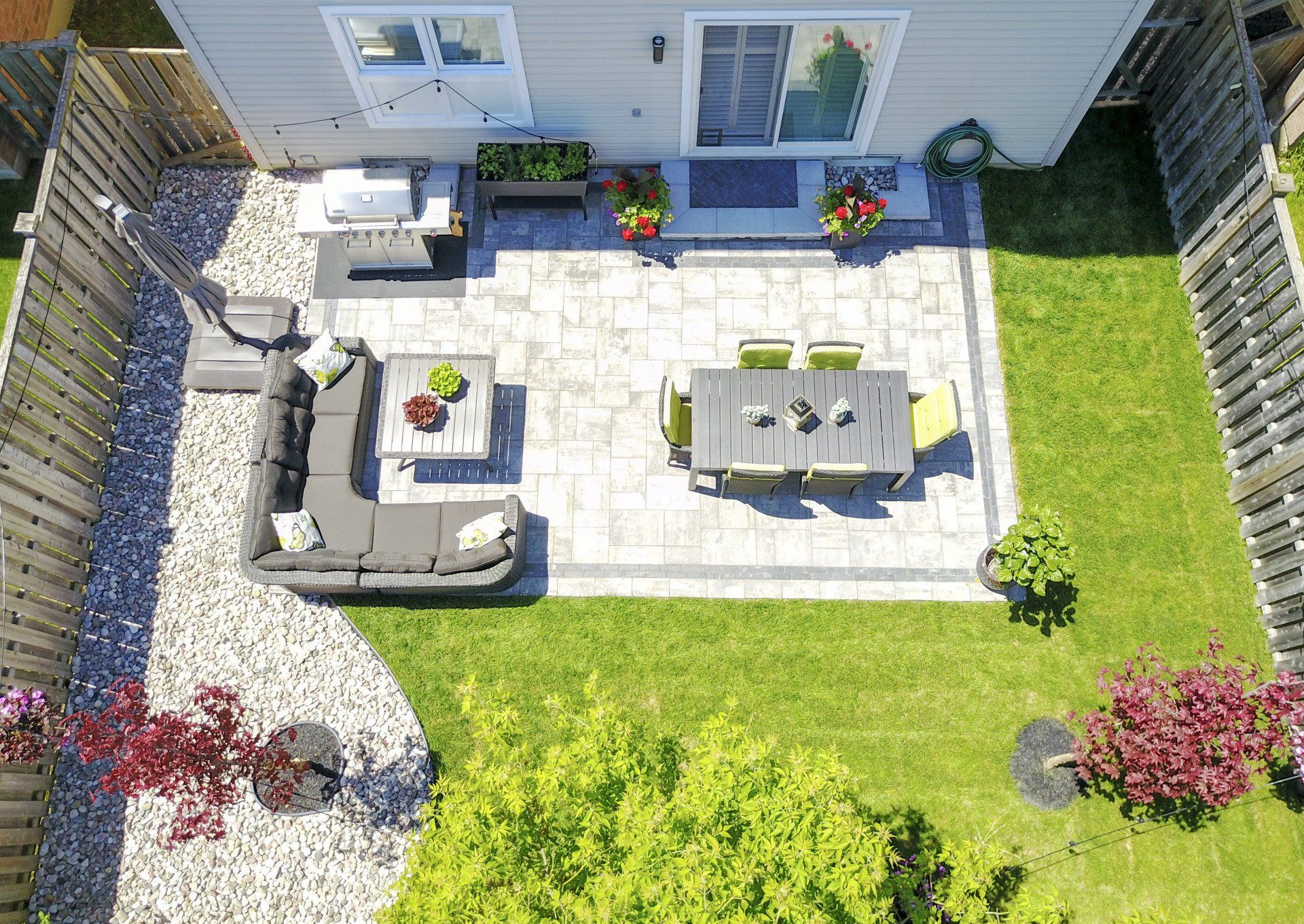 An aerial view of a backyard with a patio and a table and chairs.