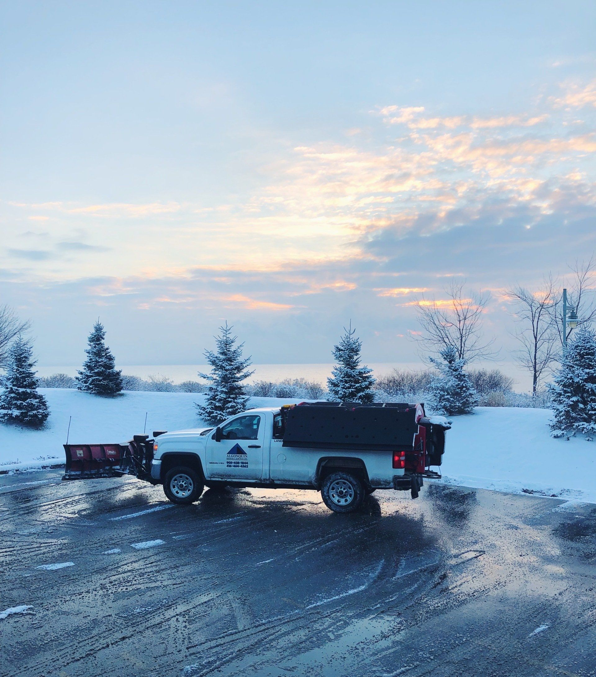 A white truck is parked in a snowy parking lot