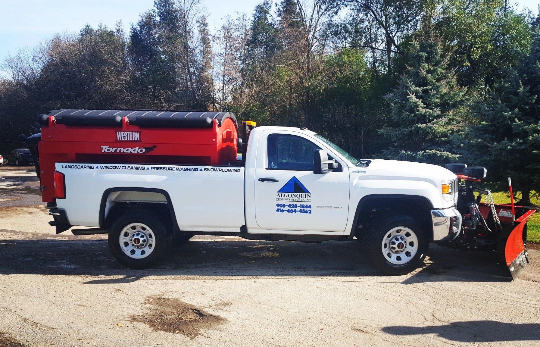 A white truck is parked next to a snow plow