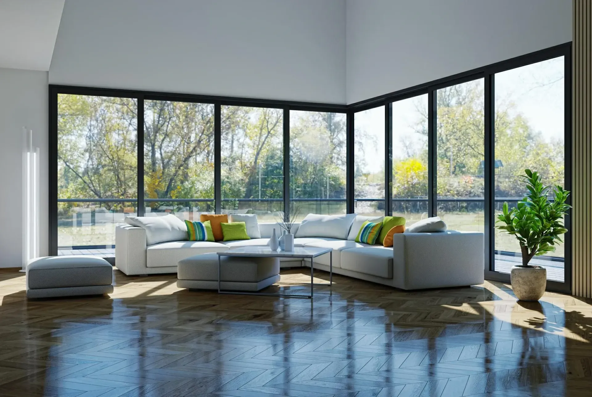 Moderna sala de estar con sofá seccional blanco, grandes ventanales, vista a los árboles y una planta en maceta.
