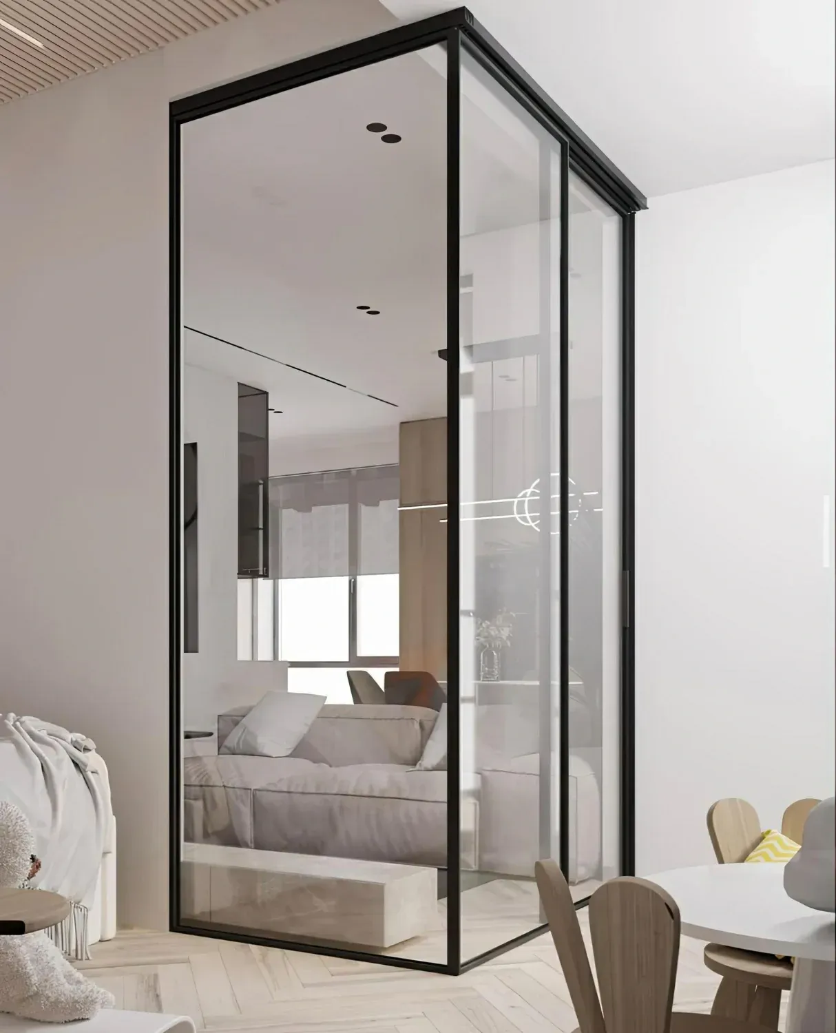 Glass-walled room with black frame, revealing a sofa, lights and window.