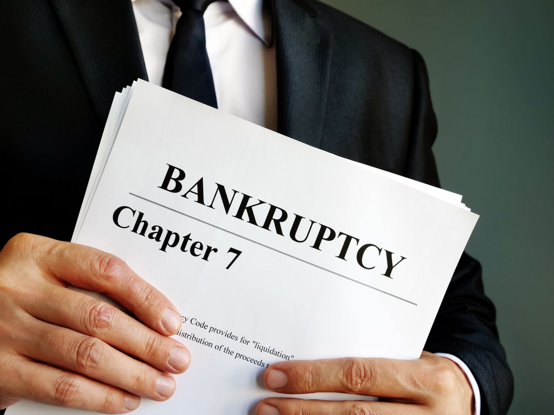 Professional hands holding Chapter 7 bankruptcy documents; consult a Chapter 7 bankruptcy attorney. Professional hands holding Chapter 7 bankruptcy documents; consult a Chapter 7 bankruptcy attorney.