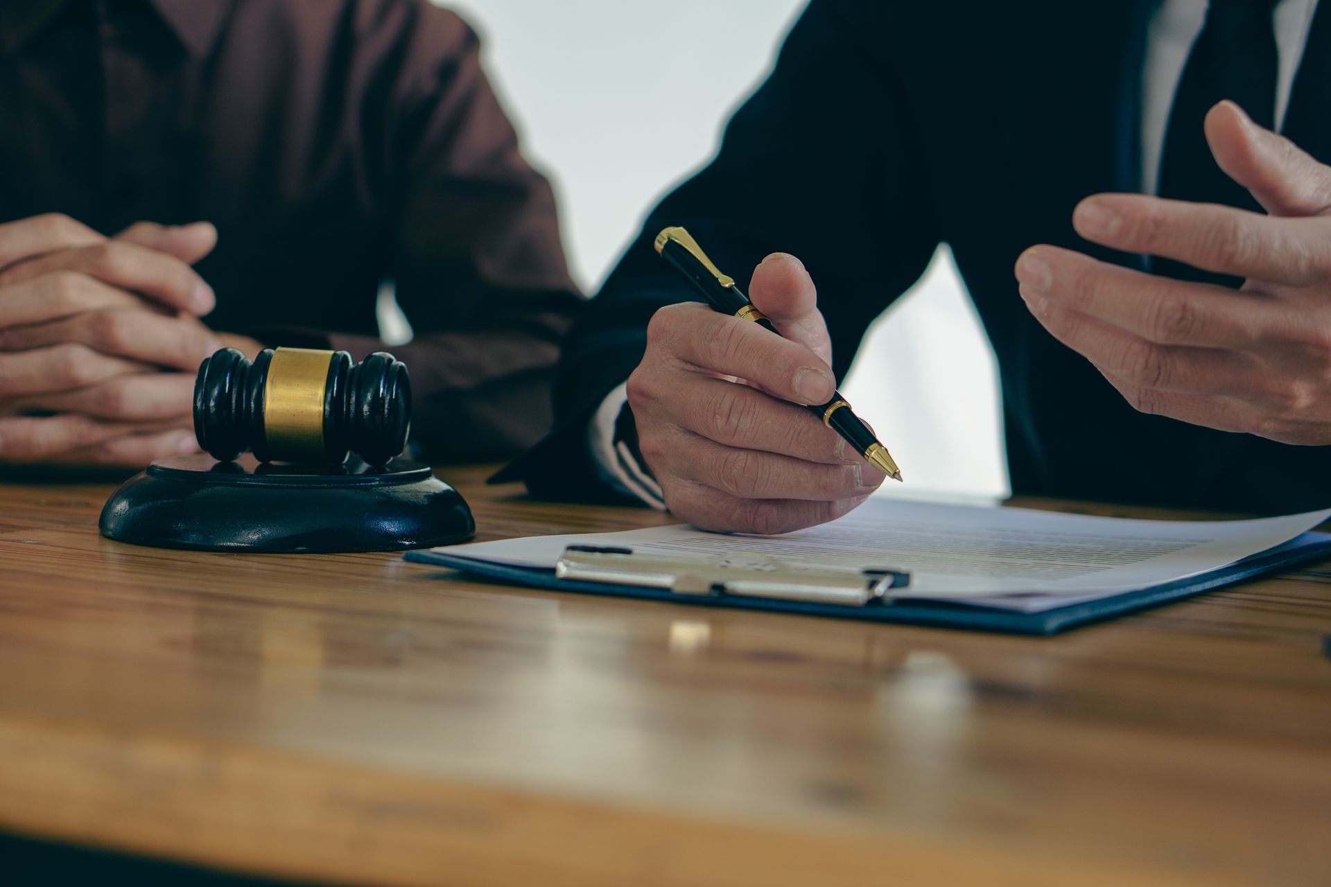 Bankruptcy firm attorney reviewing legal documents with a client beside a judge's gavel.
