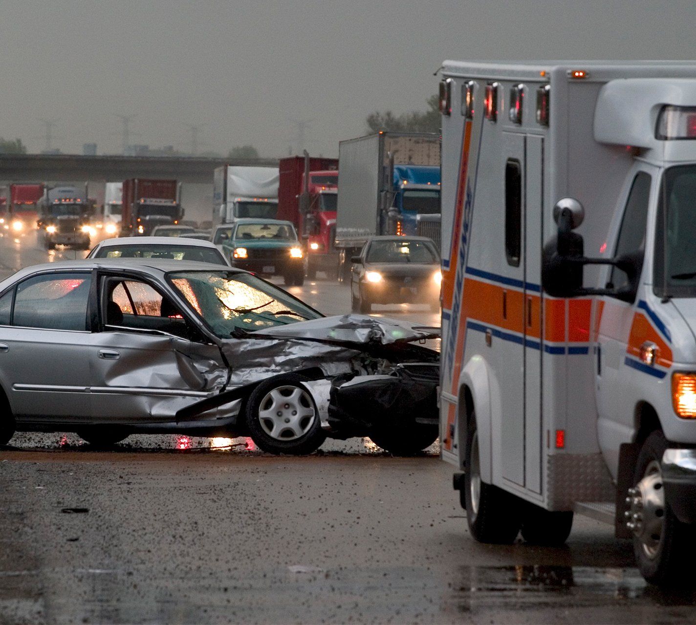 An ambulance is parked next to a damaged car