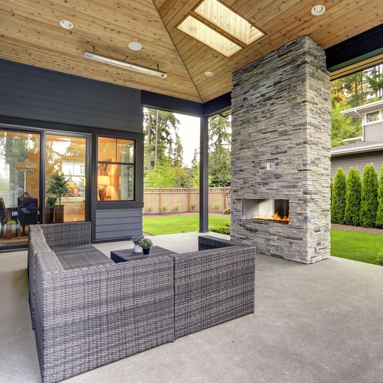 A patio with wicker furniture and a stone fireplace
