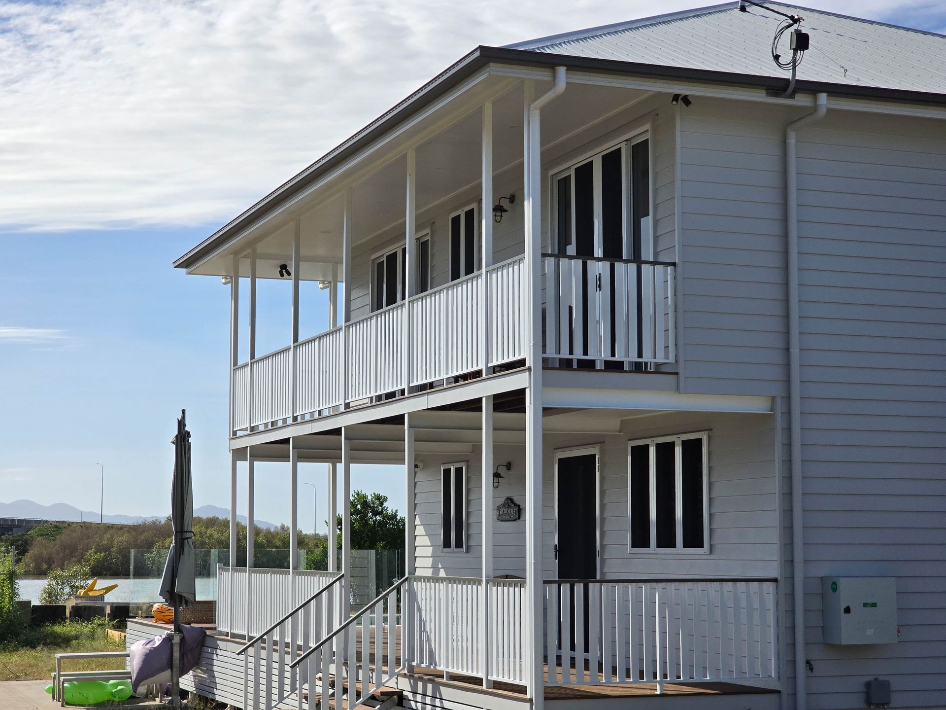 A Large House With a Lot of Windows and Balconies is Surrounded by Trees — Drawing Works In Townsville City, QLD