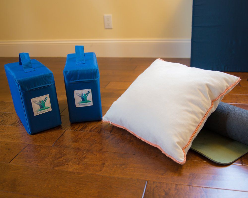 Two blue boxes and a white pillow on a wooden floor