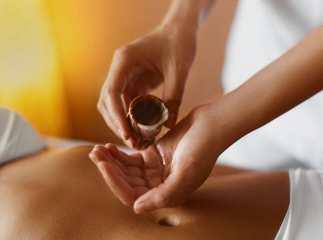 Warm aromatherapy oil being prepared for a holistic massage