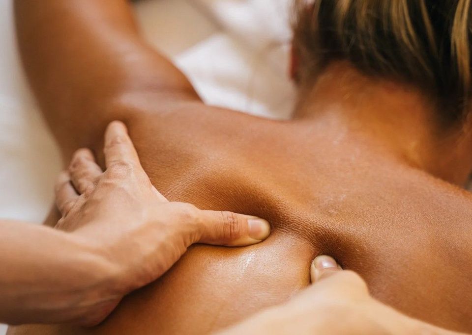 Firm sports massage pressure on the upper back and shoulder