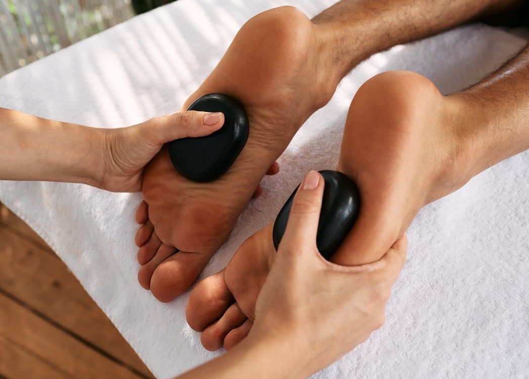 Massage Therapy Coventry using hot stone to massage feet in Coventry