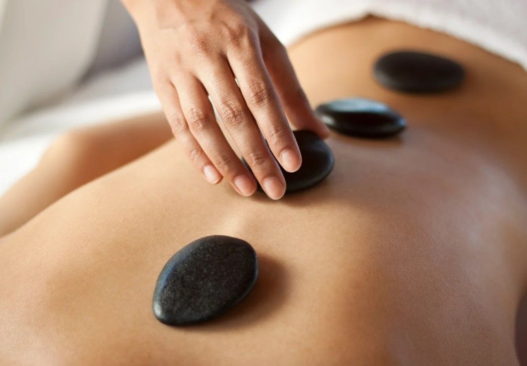 Massage Therapy Coventry placing hot rocks on a back before massaging