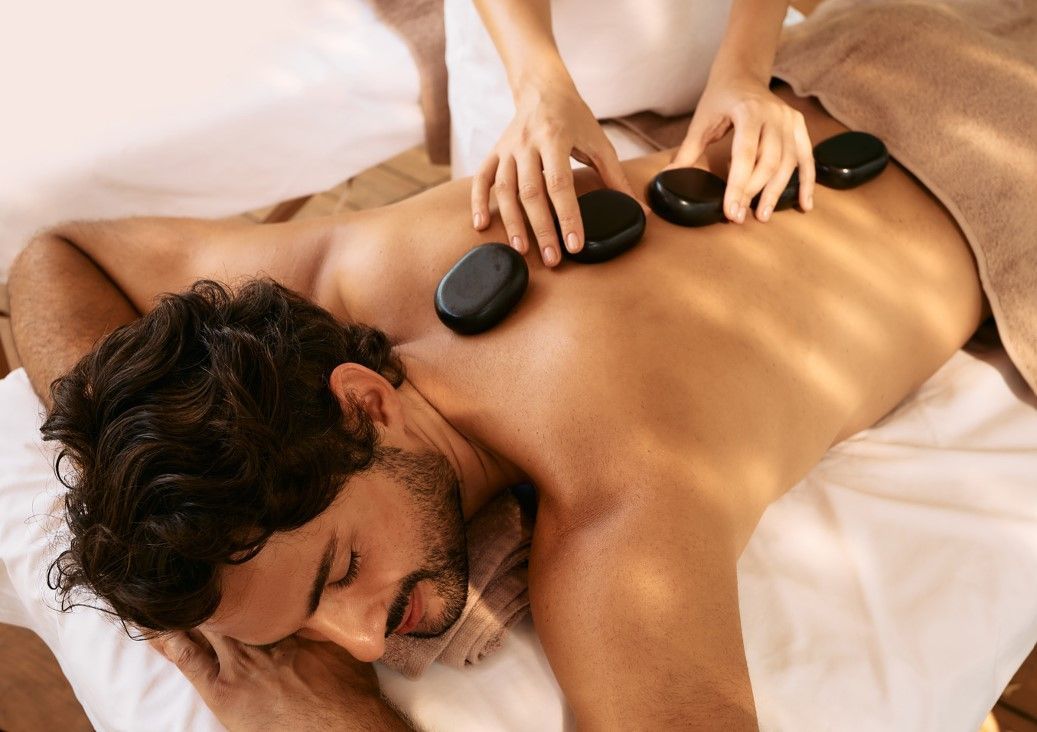 Massage Therapy Coventry adjusting hot stone on a cleint's back before massaging