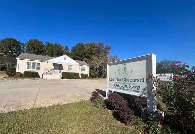 One-story building with a chiropractic sign beside a driveway on a sunny day