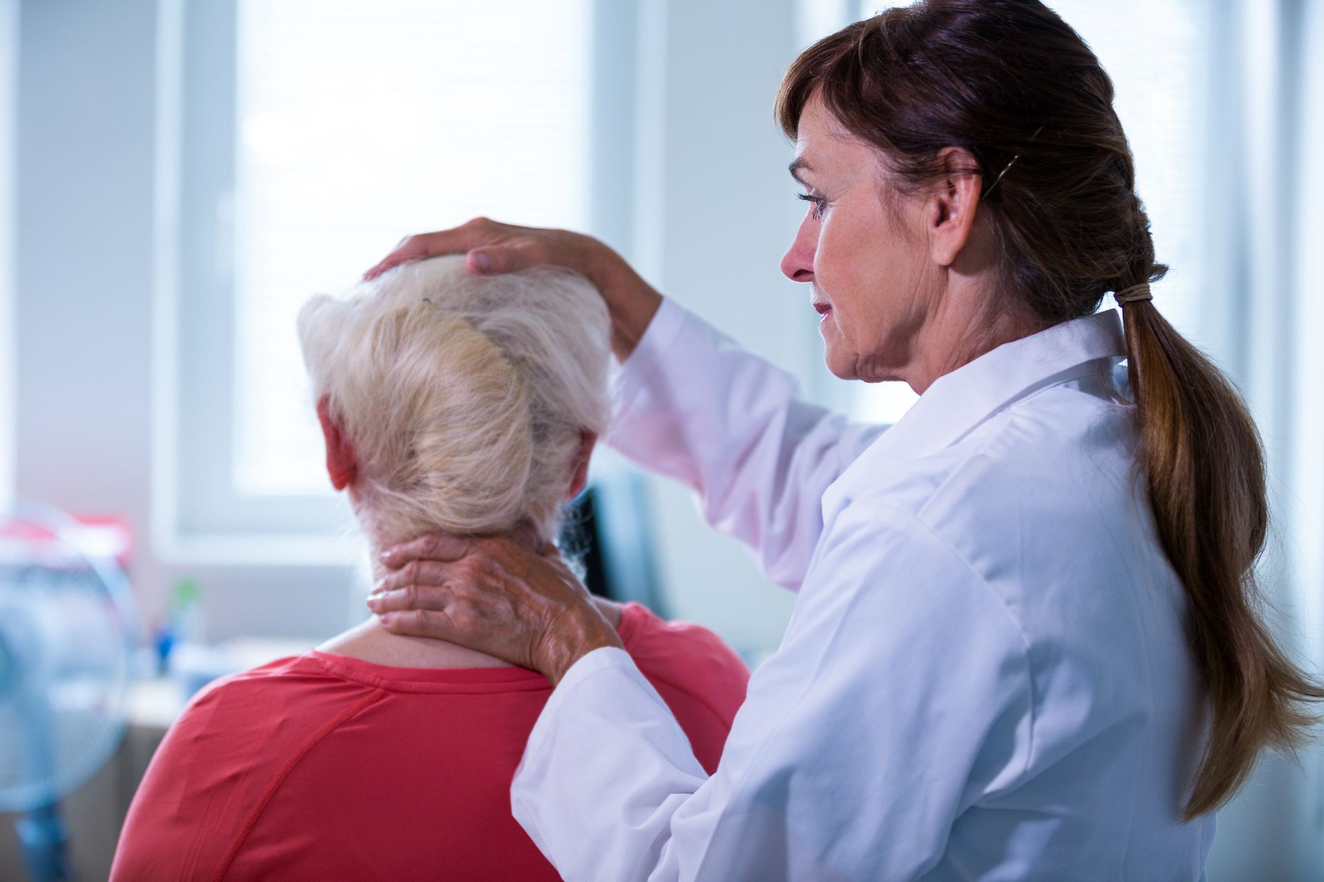 Doctor examining a patient’s neck in a clinic