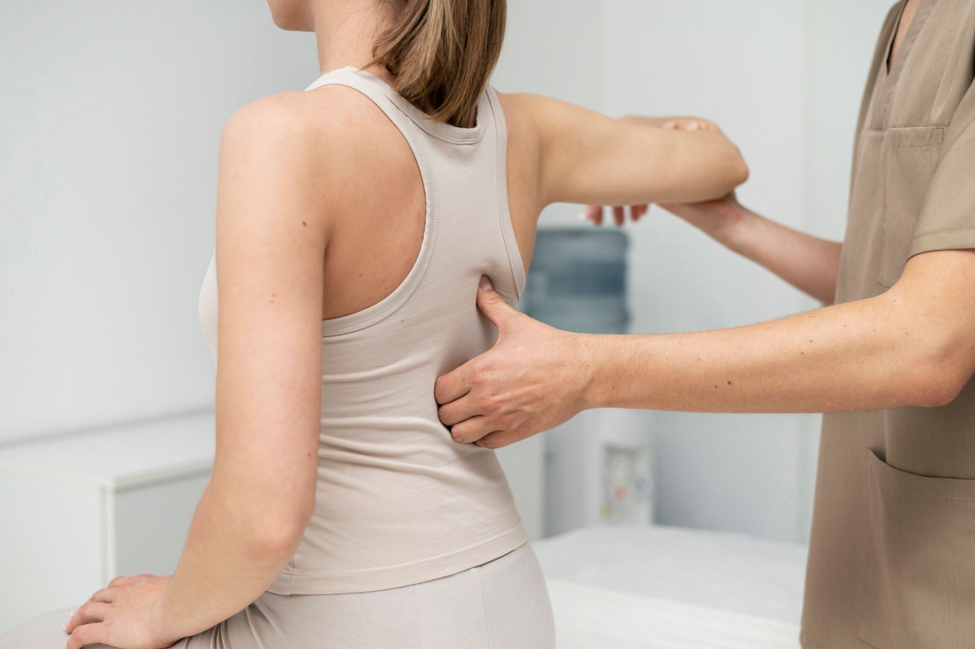 Physical therapist examining a patient’s back in a clinic room