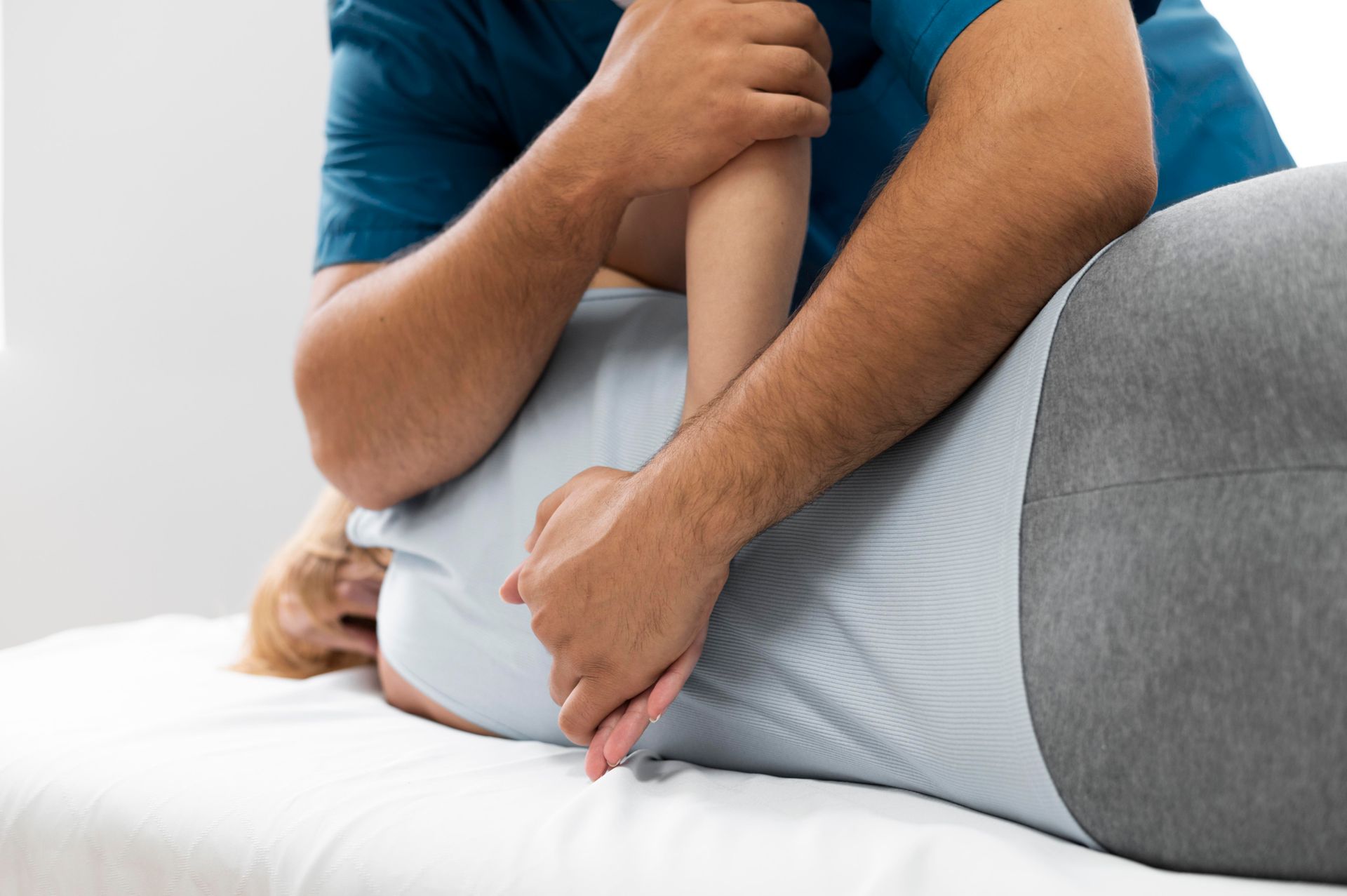 Physical therapist stretching a person’s leg on a treatment table