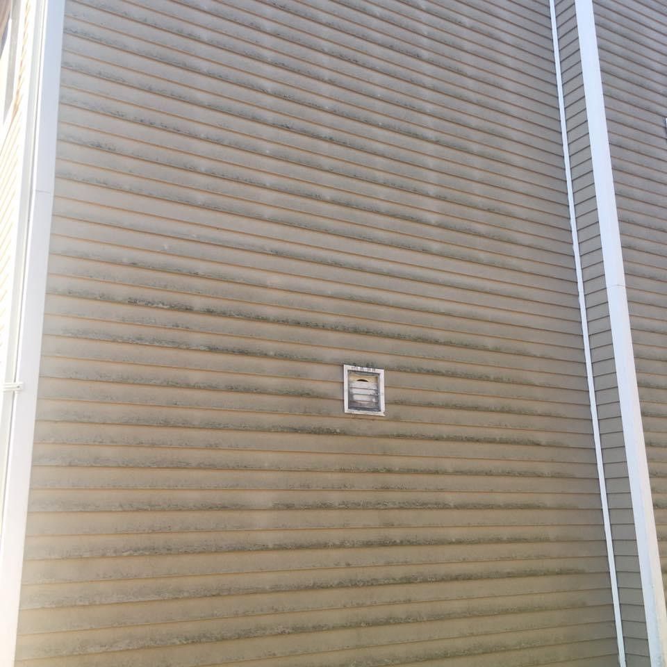 A house exterior wall with grime prior to getting residential pressure washing service.