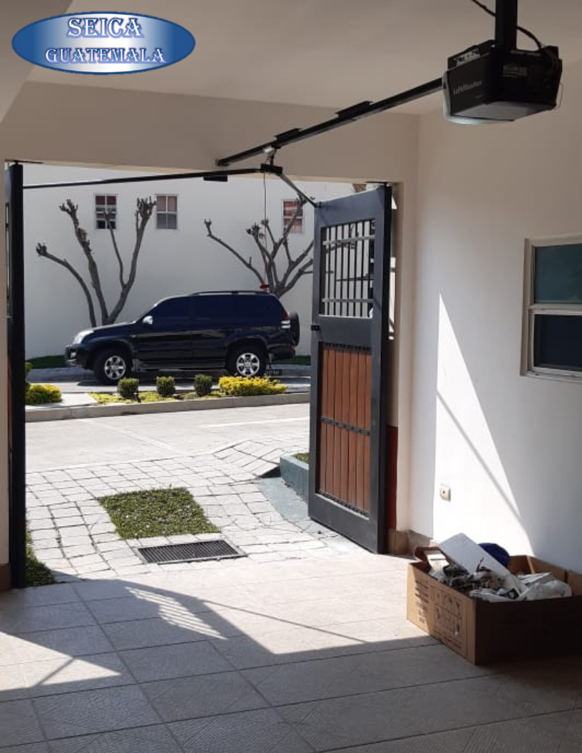 Sistema de portón automático abatible con motor de techo para residencia