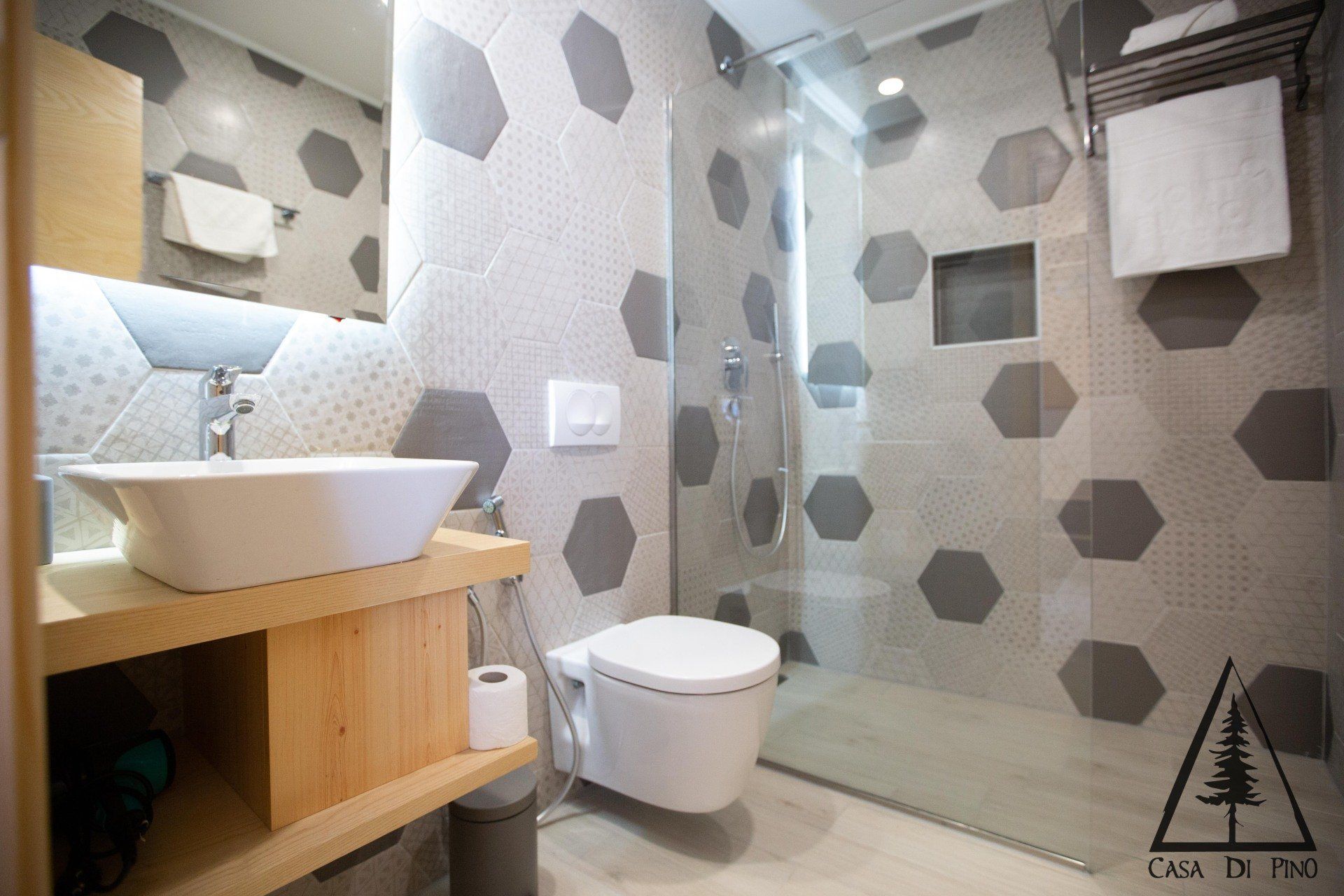 A stylish bathroom with a toilet, sink and shower.