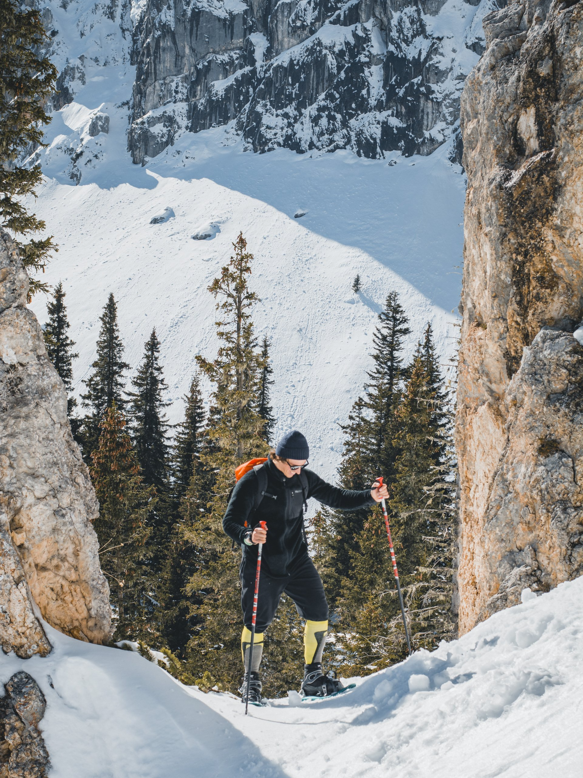 A man is snowshoeing on a snow-covered mountain.