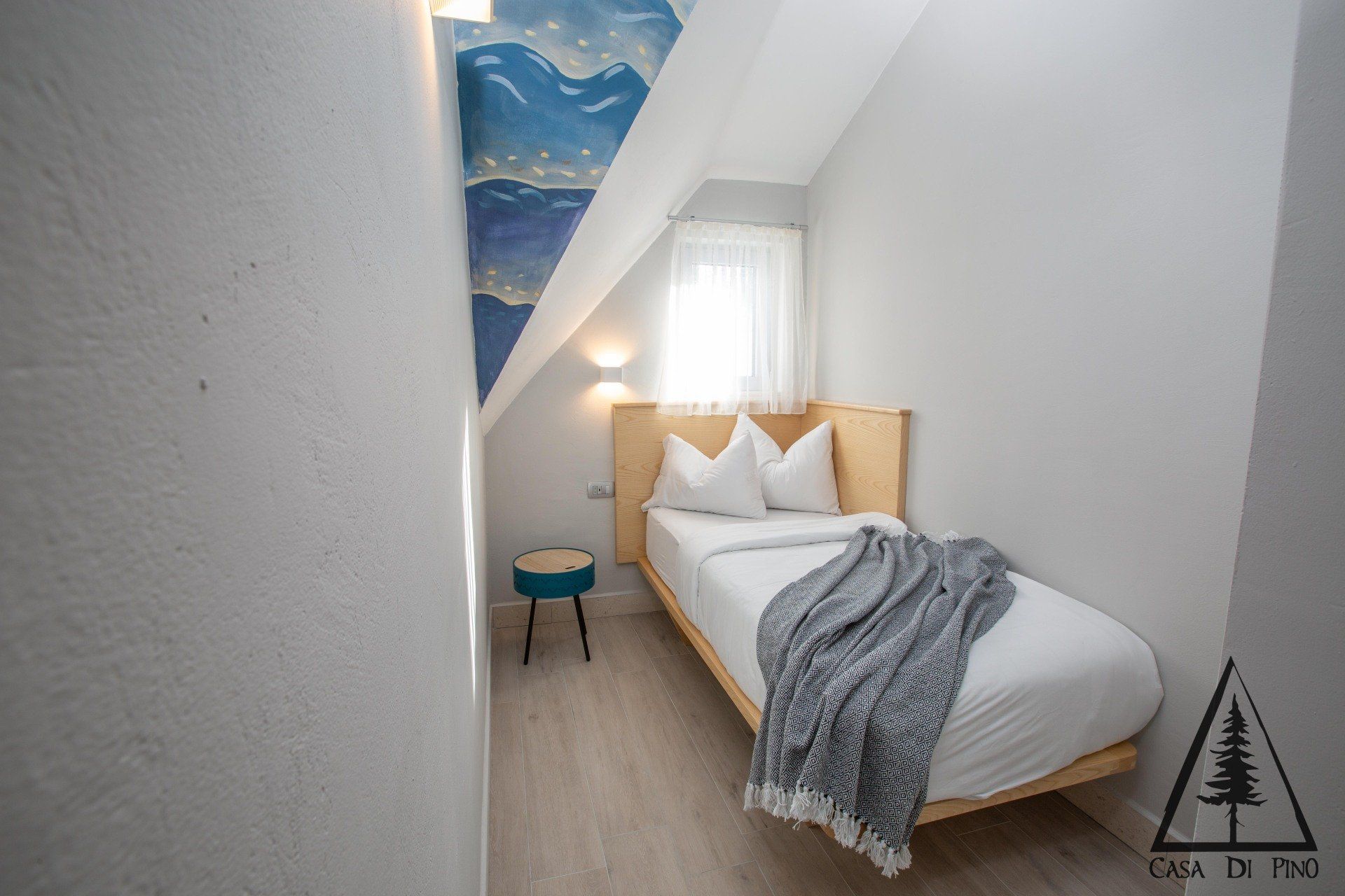A small bedroom with a single bed and a small table.