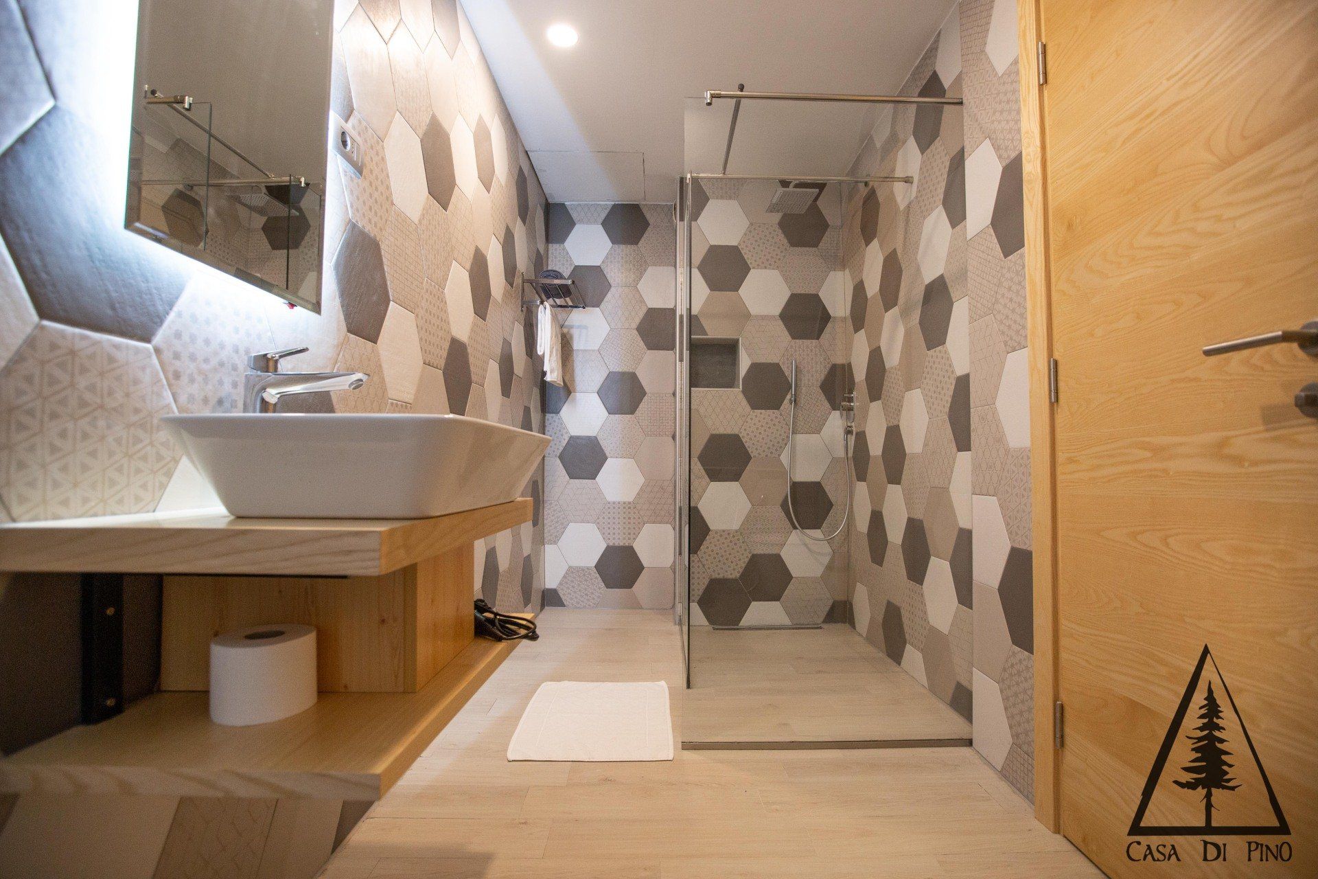 A bathroom with a sink and a walk in shower.