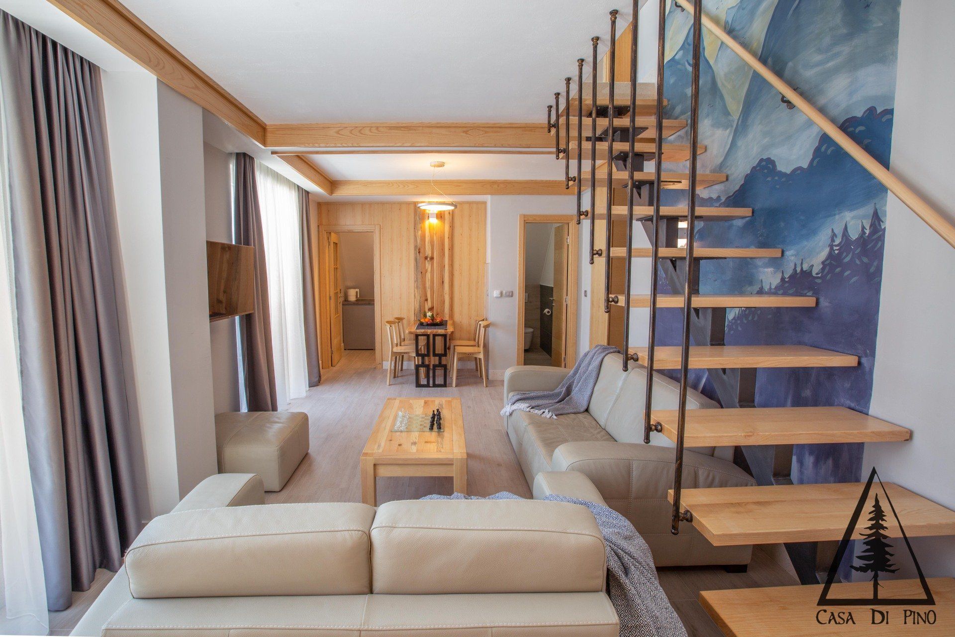 A living room in the penthouse with a staircase leading up to the second floor