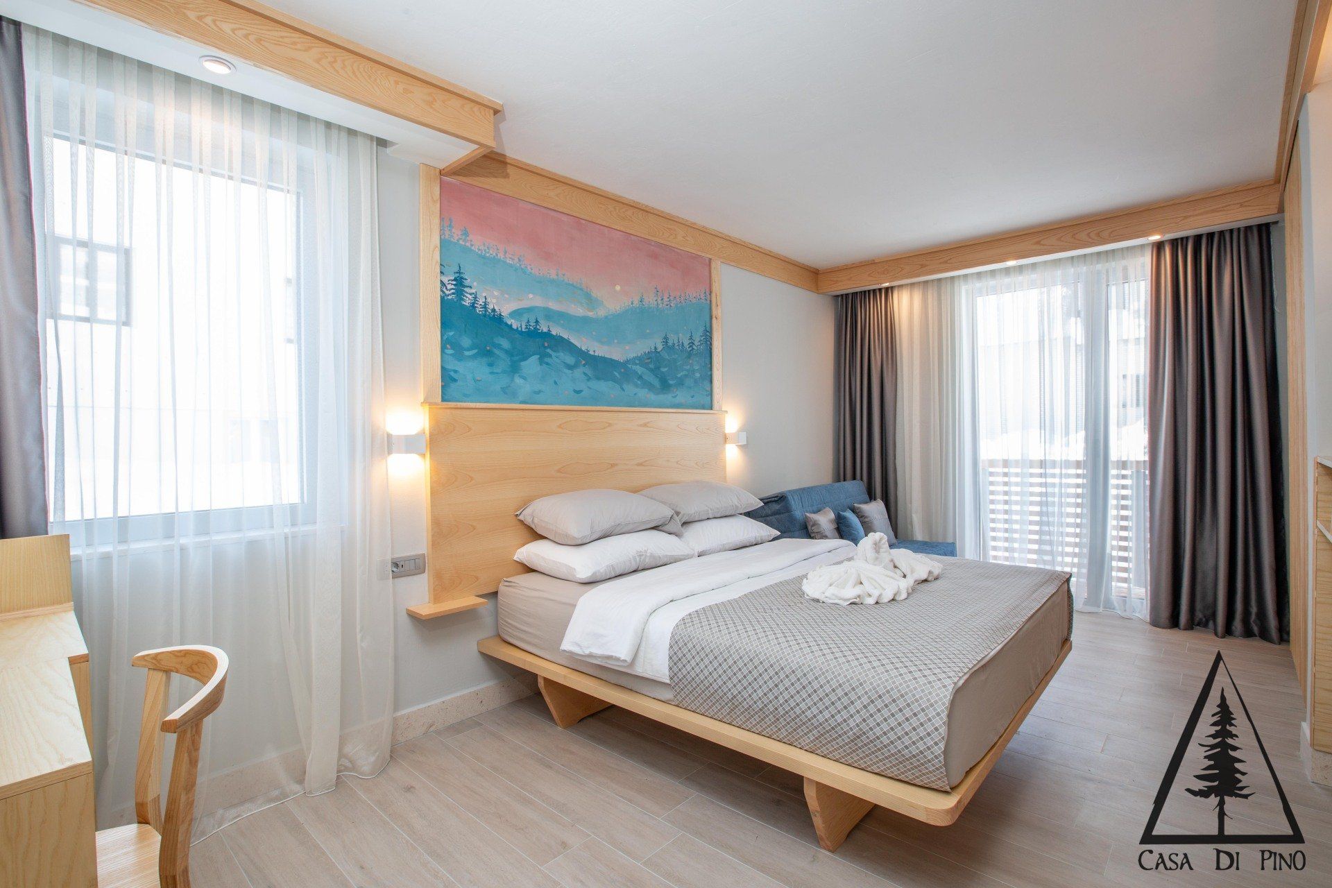 A hotel room with a large bed and a mural on the wall.