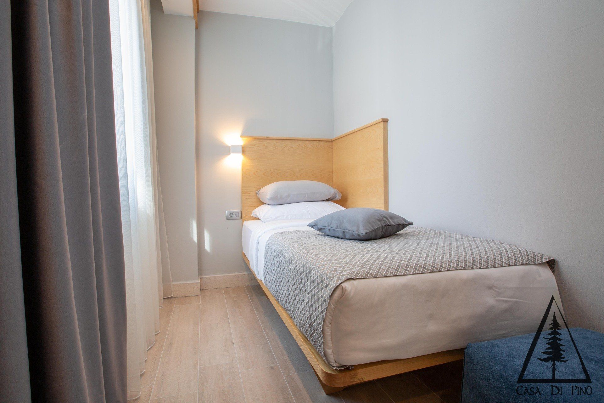 A small bedroom with a single bed and a window.