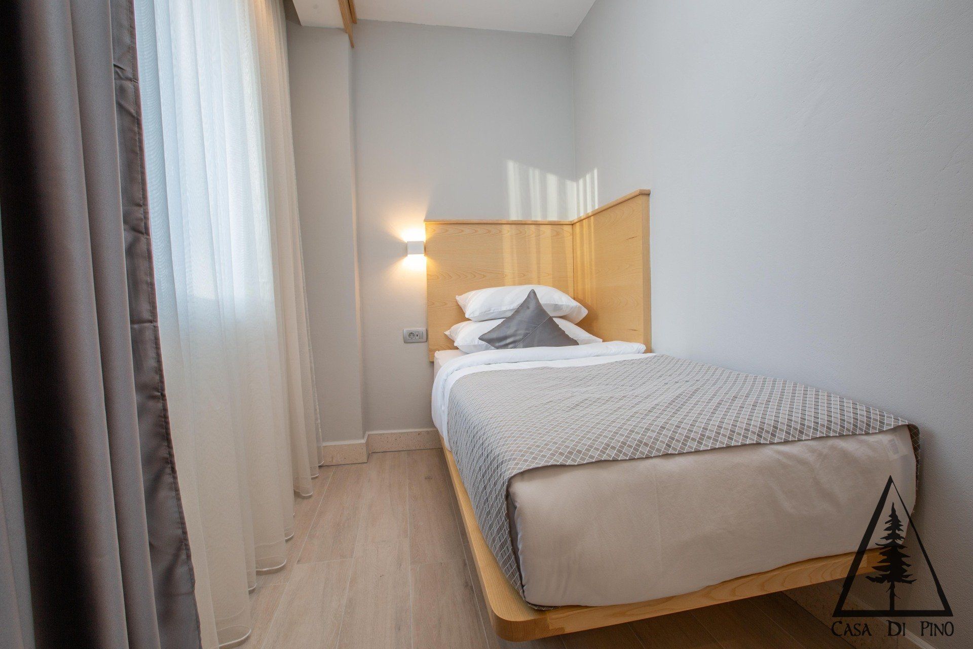 A bedroom with a single bed and a window.