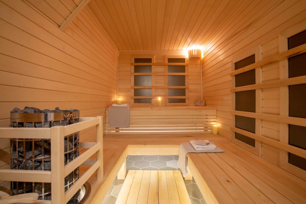 A wooden sauna with a wooden bench and heaters