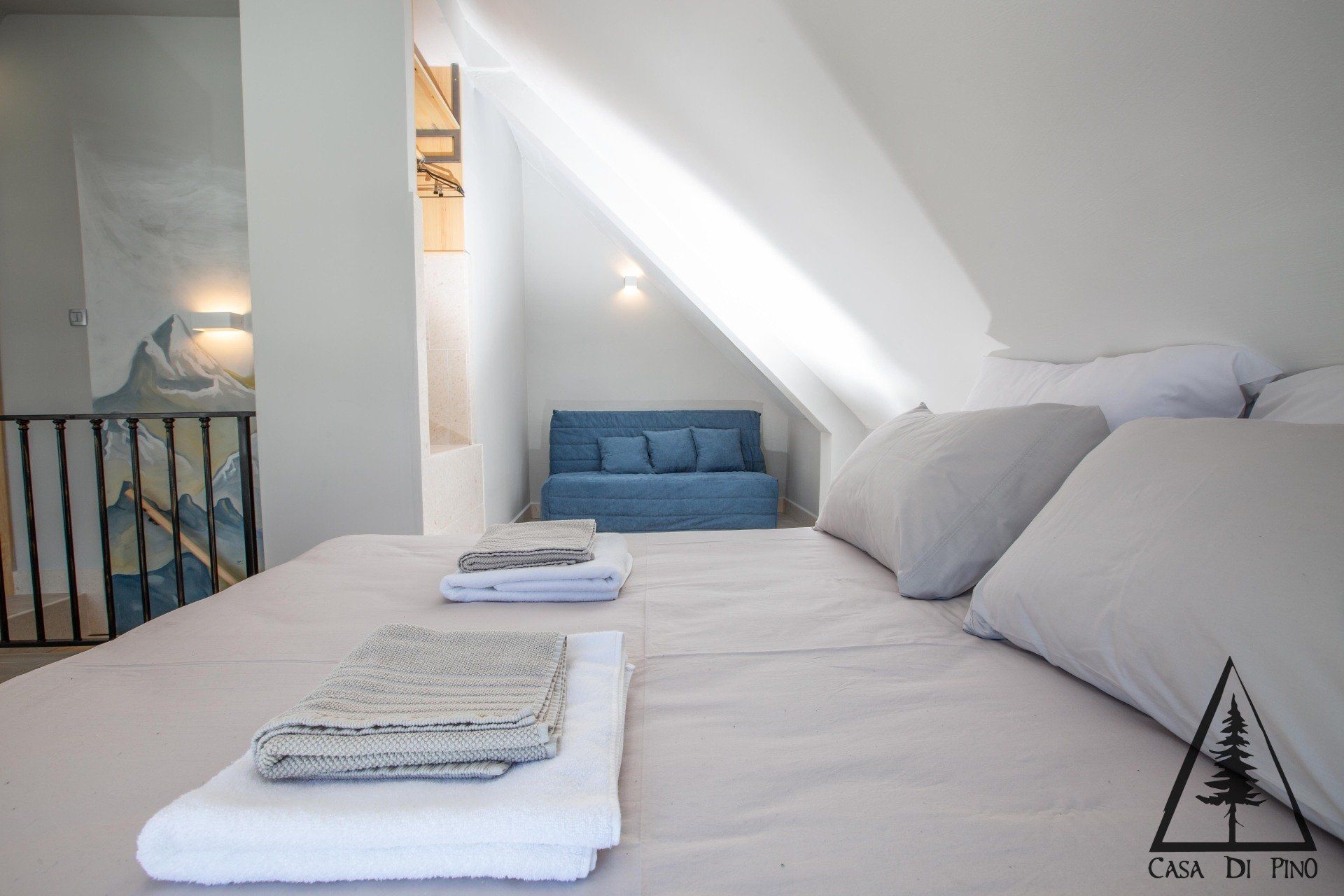 A bedroom with a bed and a blue couch