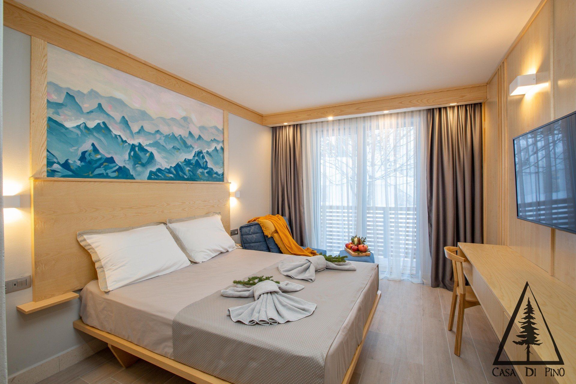 A hotel room with a large bed and a television.