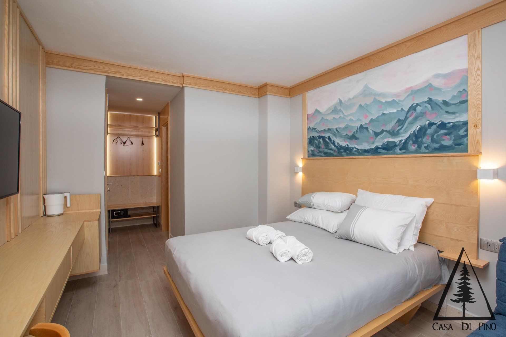 A hotel room with a large bed and a mural on the wall.